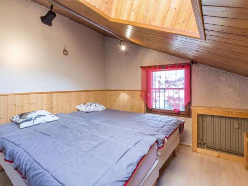 a bedroom with a large bed with a red window at Studio 3*** aux pistes, cheminée, animaux admis, garage - FR-1-304-111 in La Clusaz