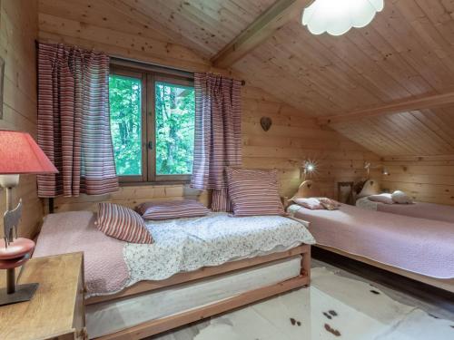 sypialnia z 2 łóżkami w drewnianym domku w obiekcie Appartement La Clusaz, 4 pièces, 6 personnes - FR-1-304-214 w mieście Clusaz