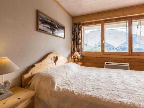 une chambre avec un lit et une fenêtre dans l'établissement Charmant 2 pièces avec coin nuit, parking et vue montagne à La Clusaz - FR-1-304-105, à La Clusaz