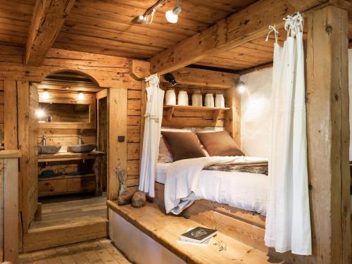une chambre avec un lit dans une cabane en rondins dans l'établissement Chalet 3*, ferme rénovée, 10 pers, proche pistes, garage, animaux admis - FR-1-304-162, à La Clusaz