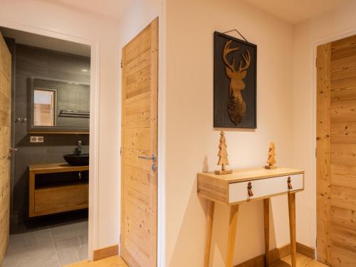 un couloir avec une porte et une table ainsi qu'une salle de bains. dans l'établissement Chaleureux appart 2 pièces près des pistes 4 pers 3*** - FR-1-304-272, à La Clusaz
