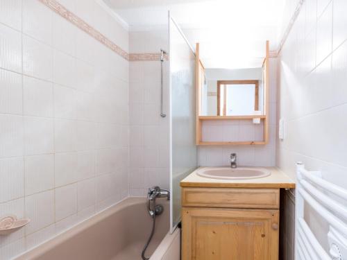 a bathroom with a sink and a tub and a mirror at Appartement La Clusaz, 2 pièces, 5 personnes - FR-1-304-53 in La Clusaz