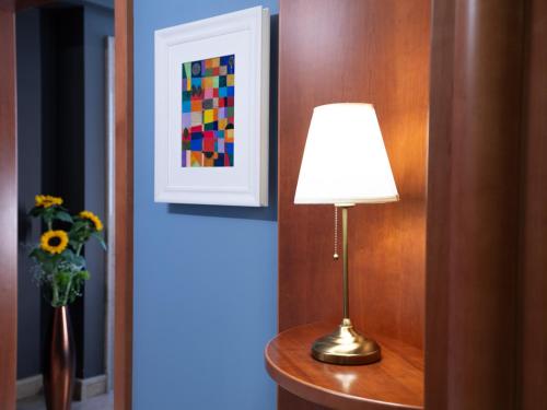 a lamp on a table next to a vase of flowers at Hotel SAN PIO in San Giovanni Rotondo