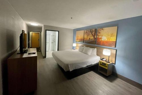 um quarto com uma cama e um quadro na parede em Days Inn by Wyndham Shawnee em Shawnee