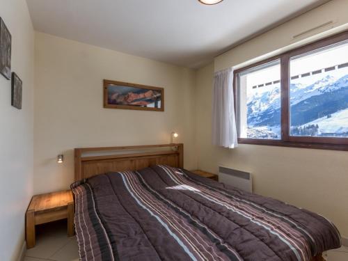- une chambre avec un lit et une fenêtre donnant sur les montagnes dans l'établissement Charmant 2 pièces avec parking, proche des pistes - FR-1-304-107, à La Clusaz