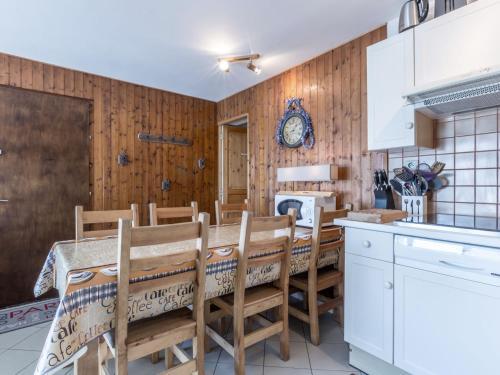 une cuisine avec une table et des chaises ainsi qu'une cheminée dans l'établissement Charmant 2 pièces avec parking, proche des pistes - FR-1-304-107, à La Clusaz