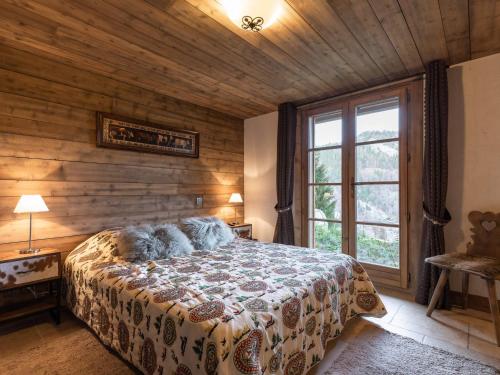 ein Schlafzimmer mit einem Bett und einem großen Fenster in der Unterkunft Chalet La Clusaz, 5 pièces, 8 personnes - FR-1-304-110 in La Clusaz