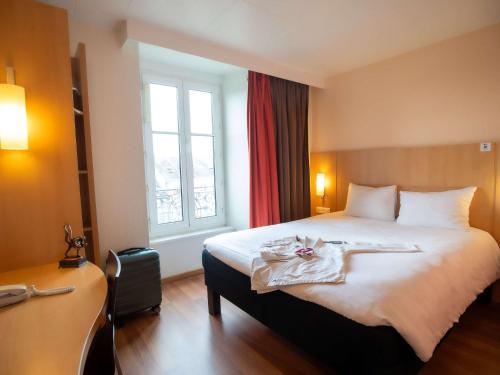 una camera d'albergo con letto e finestra di ibis Limoges Centre a Limoges