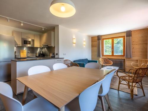 une cuisine et une salle à manger avec une table et des chaises en bois dans l'établissement 4 pièces près des pistes avec balcon - La Clusaz - FR-1-304-205, à La Clusaz