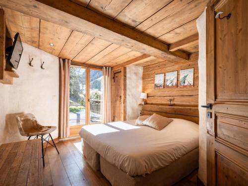 una camera con un letto in una stanza con pareti in legno di Appartement La Clusaz, 4 pièces, 7 personnes - FR-1-304-232 a La Clusaz