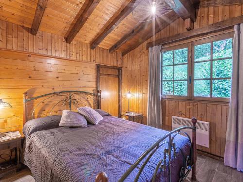 une chambre avec un lit dans une pièce aux murs en bois dans l'établissement Chalet 8 pers, proche pistes, 3***, balcon, cheminée - FR-1-304-243, à La Clusaz