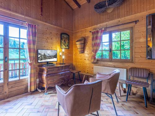Il comprend un salon doté d'une télévision, d'un bureau et de chaises. dans l'établissement Chalet 8 pers, proche pistes, 3***, balcon, cheminée - FR-1-304-243, à La Clusaz