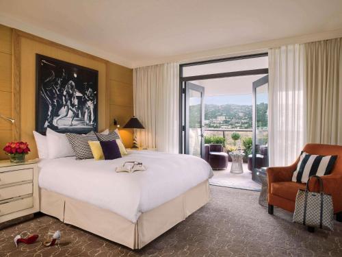 sypialnia z dużym białym łóżkiem i krzesłem w obiekcie Hotel Sofitel Los Angeles at Beverly Hills w Los Angeles