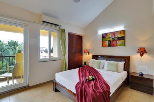 a bedroom with a bed and a large window at Veera Strand Park Serviced Apartments near Calangute in Calangute