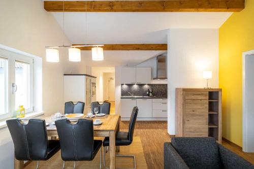 ein Esszimmer mit Tisch und Stühlen und eine Küche in der Unterkunft Ferienwohnung "Bernstein" im Ostsee-Domizil Sandburg in Kühlungsborn