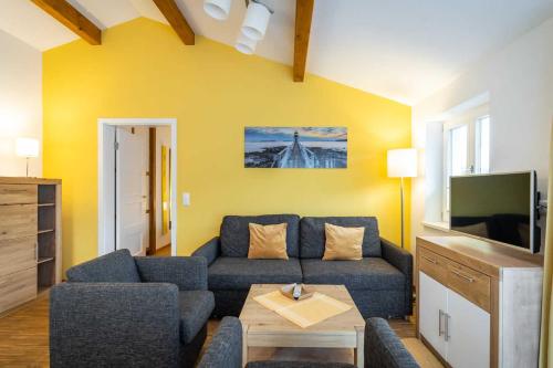 ein Wohnzimmer mit einem blauen Sofa und einem Fernseher in der Unterkunft Ferienwohnung "Bernstein" im Ostsee-Domizil Sandburg in Kühlungsborn