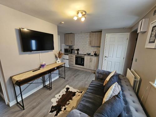 a living room with a couch and a table with a tv at Beautiful 'n' Cosy - City Center in Etruria