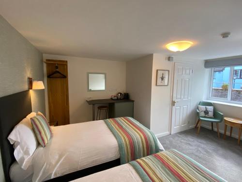 a bedroom with two beds and a table and a chair at Gordons in Cheddar