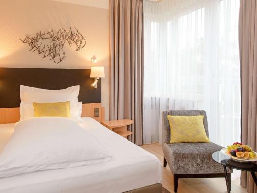 ein Hotelzimmer mit einem Bett und einem Stuhl in der Unterkunft Mercure Hotel Koeln Belfortstrasse in Köln