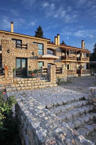 a large stone house with a stone path in front of it at Αέσκω in Vytina