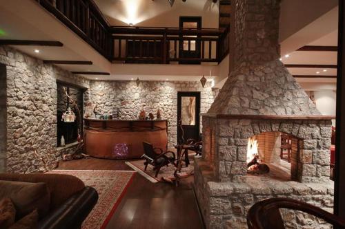 a living room with a stone fireplace and a couch at Αέσκω in Vytina