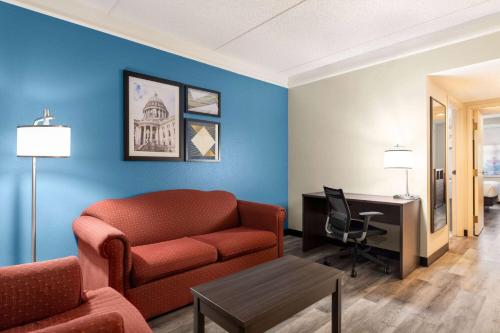 a living room with a couch and a desk at La Quinta by Wyndham Madison American Center in Madison