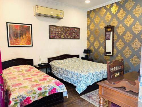 a bedroom with two beds and a table at Vandana's Bed and breakfast in New Delhi