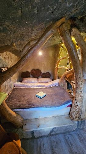 a bed in a log cabin with a book on it at Zemljane kućice Kreševo in Kreševo