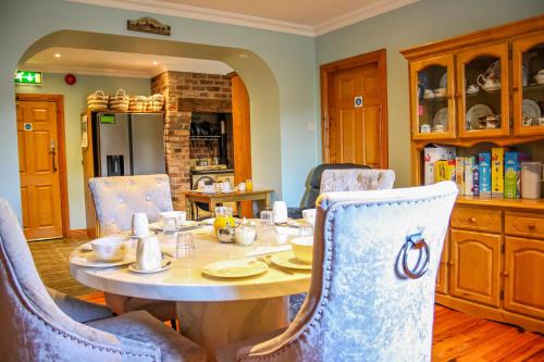 uma sala de jantar com mesa e cadeiras em The Coach Inn em Strabane