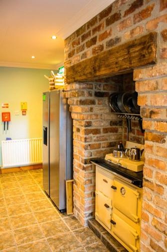 a kitchen with a brick wall and a stainless steel refrigerator at The Coach Inn in Strabane