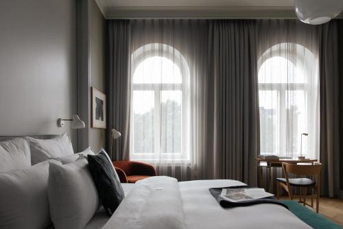 a hotel room with a bed and two windows at Hotel St. George Helsinki in Helsinki