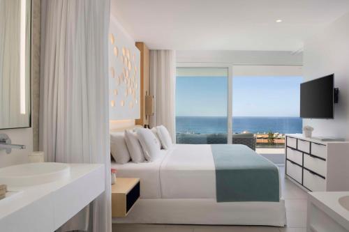 a bedroom with a bed and a view of the ocean at Royal Hideaway Corales Suites in Adeje