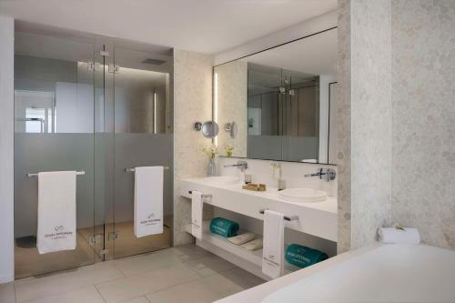 y baño con bañera, lavabo y espejo. en Royal Hideaway Corales Suites, en Adeje