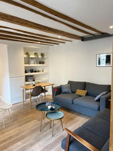 un salon avec un canapé bleu et une table dans l'établissement Appartement de charme en plein cœur de Paris, à Paris