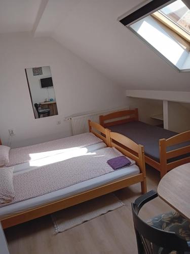 een kamer met 2 bedden, een tafel en een raam bij SOBE ŠOKČIĆ in Karlovac