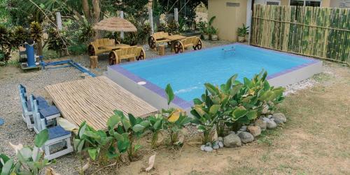a large swimming pool in a yard with tables and chairs at Dome tent in Elyu will Pool Access for 10 pax 