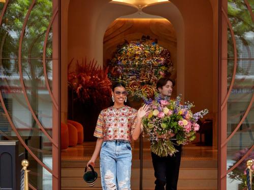 two women standing in front of a building holding flowers at SO/ Paris Hotel in Paris