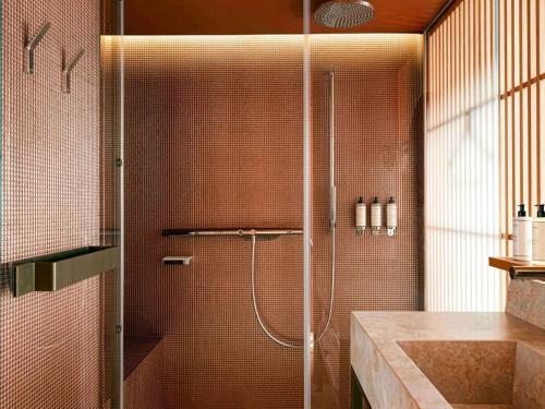 um chuveiro com uma porta de vidro na casa de banho em SO/ Paris Hotel em Paris