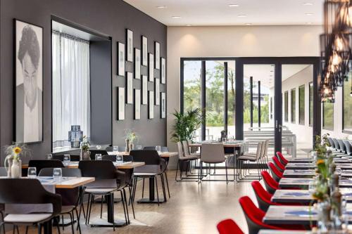 un ristorante con tavoli, sedie e finestre di Vienna House by Wyndham Ernst Leitz Wetzlar a Wetzlar