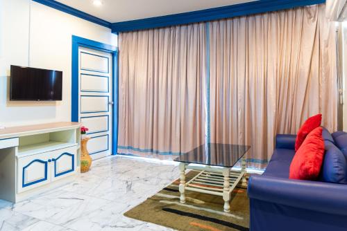 a living room with a blue couch and a table at 75 Paradise Lane Managed by Loft Group in Bangkok