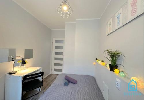 a bedroom with a desk and a bed and a table at Pineapple Room in Gdańsk