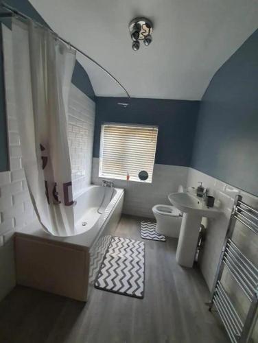 y baño con bañera, aseo y lavamanos. en Single Bedroom 96GLA Greater Manchester, en Middleton