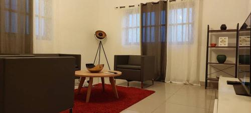 ein Wohnzimmer mit einem Tisch und einem Stuhl in der Unterkunft Chic cadjehoun in Cotonou