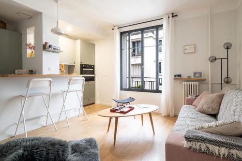 un salon avec un canapé et une table dans l'établissement Appartement Pompadour - Welkeys, à Boulogne-Billancourt