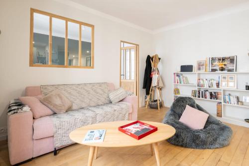 un salon avec un canapé et une table dans l'établissement Appartement Pompadour - Welkeys, à Boulogne-Billancourt