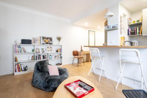 un salon avec une table et des chaises et une cuisine dans l'établissement Appartement Pompadour - Welkeys, à Boulogne-Billancourt