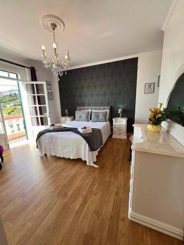 1 dormitorio con cama y lámpara de araña en Blue Paradise Apartment, en Ribeira Brava