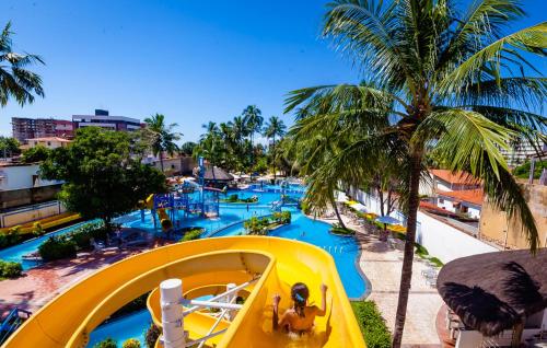 a yellow slide at a water park with people on it at Matsubara Acqua Park Hotel in Maceió