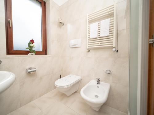 a white bathroom with a toilet and a sink at Hotel SAN PIO in San Giovanni Rotondo