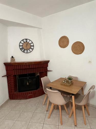 a dining room with a table and chairs and a fireplace at Maria Apts in Istron